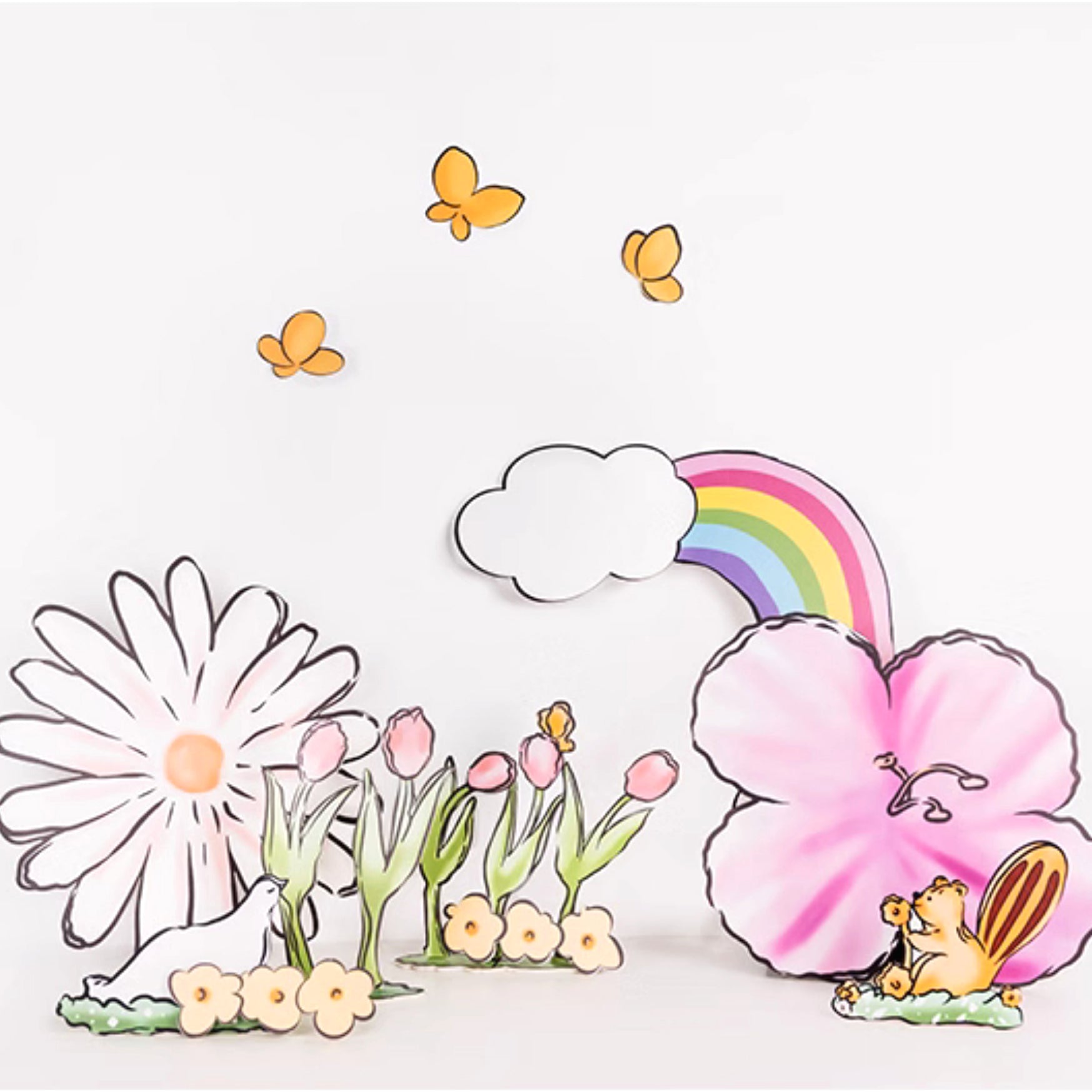 Illustration of a whimsical spring scene with vibrant flowers, including a large daisy and hibiscus, tulips, and smaller blossoms. Butterflies flutter above, a rainbow arcs from a cloud, and cheerful chipmunks stand near the pink hibiscus flower—perfect as **Rainbow Tulip Garden Cutouts | 16pc Watercolor Daisy & Squirrel Decor | Baby Shower & Birthday Props by Eanjia** for a party.