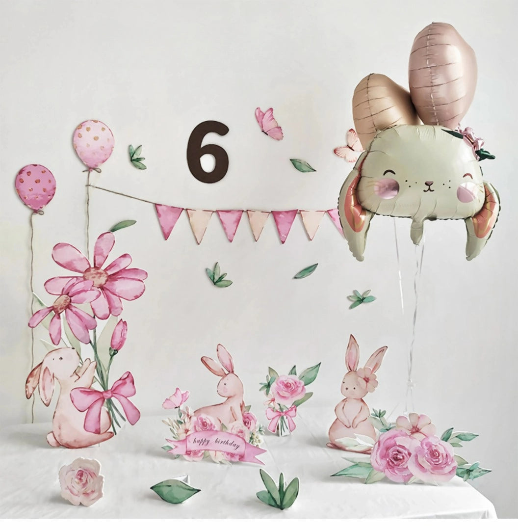 A whimsical birthday decoration featuring a large number 6, pastel-colored balloons, a bunny-themed banner, and various bunny illustrations with flowers. Standee cutouts for the party include rabbit-shaped balloons and flower arrangements, all set in a light, festive setting. The Pink Bunny Flower Balloons Standee Party Decoration Foam Board Cutout Set 30pcs by Dongguan Quanjia Trade Co.,ltd completes the look perfectly.